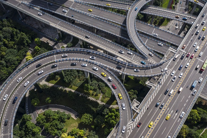 Vehicles travel along an elevated highway interchange above Egongyan Park in Chongqing on July 29. Photo: Bloomberg