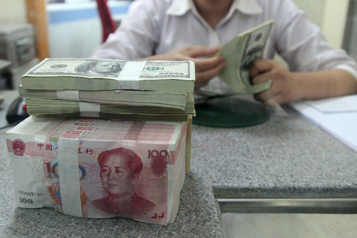 pictureA bank employee counts U.S. dollars in East China’s Jiangsu province in October 2021. Photo: VCG