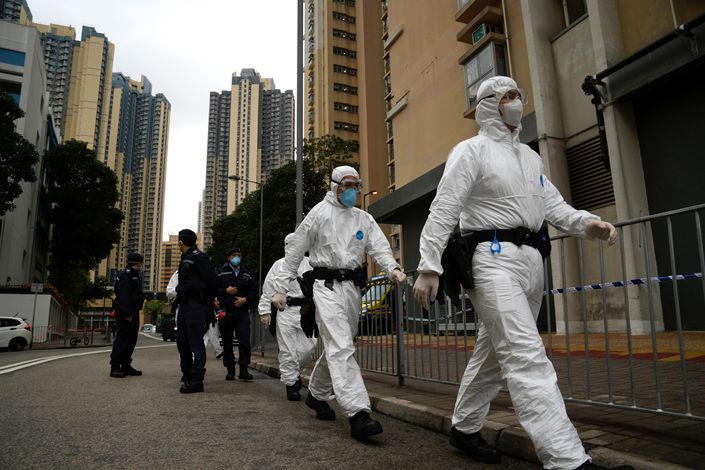 Police officers in protective gear guard at the lockdown area in Kwai Chung Estate in Hong Kong on Jan. 22. Photo: VCG