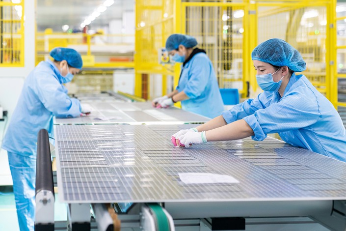 Workers rush to produce solar photovoltaic modules for export at a workshop of a new energy company in Nantong, Jiangsu Province, on Jan. 7, 2022. Photo: VCG