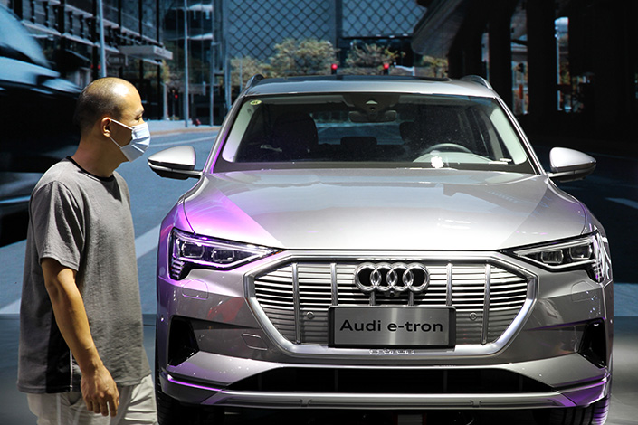 A man stands next to an Audi e-tron vehicle developed by FAW Volkswagen, in East China’s Jiangsu province, in 2020. Photo: VCG