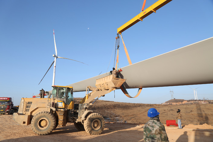 Workers install a wind turbine in Northwest China’s Gansu province in December. Photo: VCG