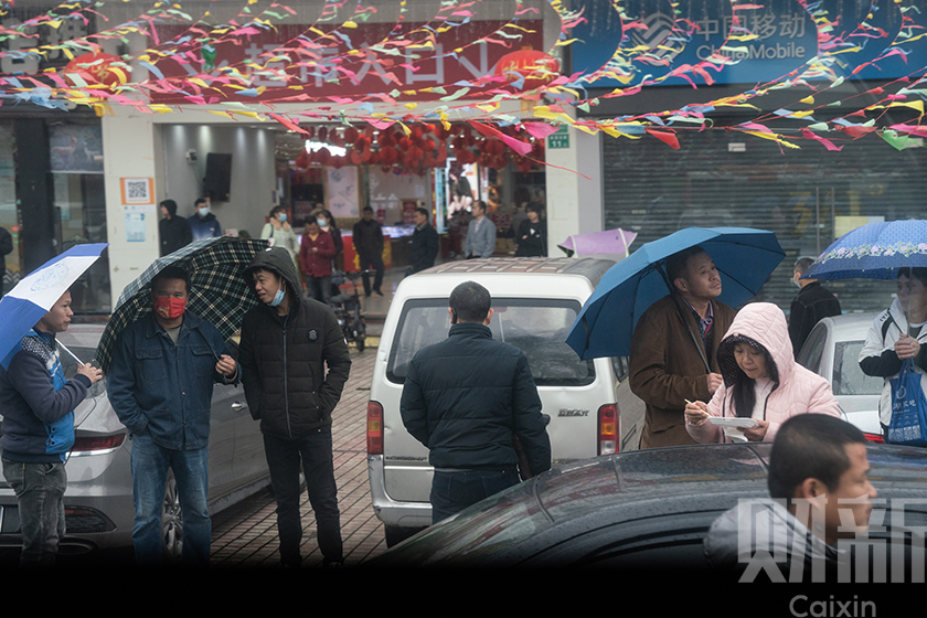 2月19日，站在街边等待聘用的日结工。湿冷的天气挡不住他们找工作的热情。