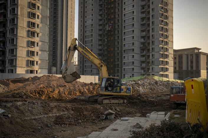 A worker operates an excavator at the construction site in Wuhan on Dec. 22. Photo: Bloomberg