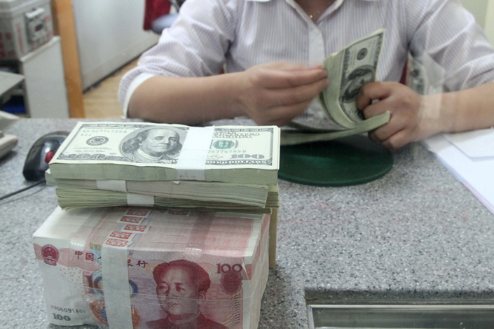 A bank employee counts U.S. dollars in East China’s Jiangsu province in October 2021. Photo: VCG