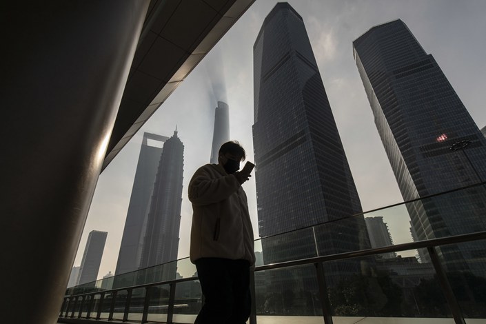 A pedestrian walks past buildings in the Lujiazui Financial District in Shanghai on Jan. 4. Photo: Bloomberg