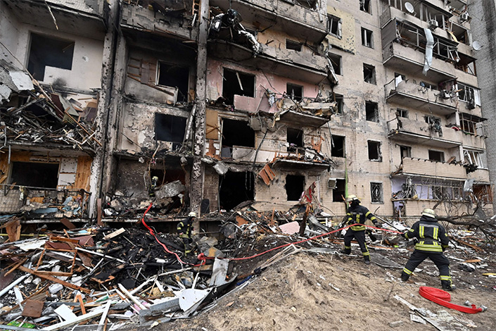 Firefighters work at a damaged residential building friday in a suburb of the Ukrainian capital Kyiv, where a military shell allegedly hit. Photo: Bloomberg