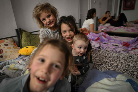 当地时间2022年2月25日，罗马尼亚边境城市Isaccea，大量乌克兰民众涌入此处避难，孩子们在当地一处临时避难所玩耍。受俄乌紧张局势的影响，一些乌克兰民众不得不撤离自己的家园寻找避难之地，在避难途中，乌克兰儿童依然展露出纯真的笑容。图/人民视觉
