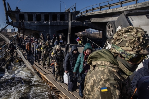 当地时间2022年3月10日，乌克兰基辅，民众撤离当地。居民走过一条被毁坏的桥。图：Chris McGrath/人民视觉