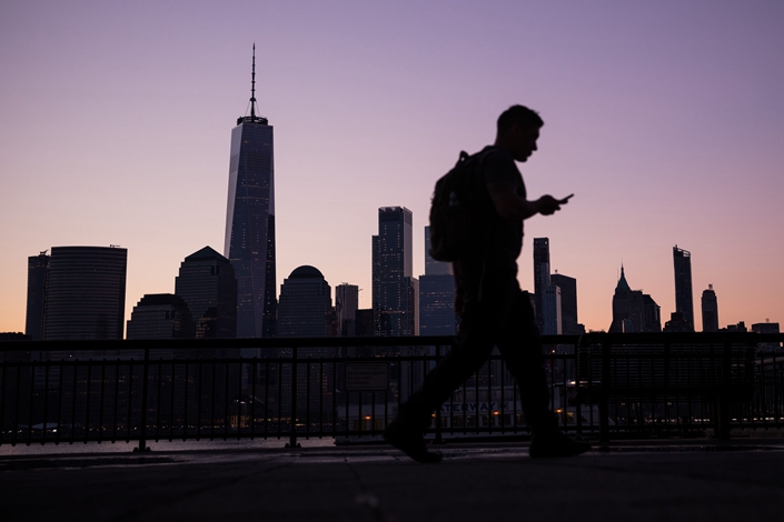 A pedestrian walks along the Hudson River Waterfront Walkway in Jersey City, the U.S., in April 2019. Photo: Bloomberg