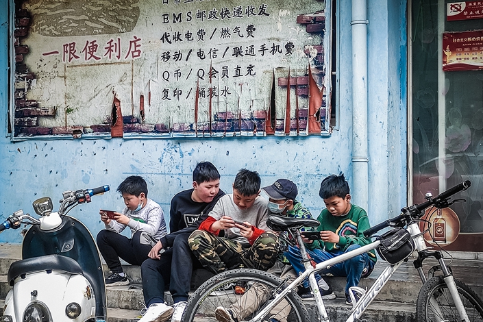 A group of children play games in front of a shop in Central China’s Henan province in May 2020. Photo: VCG