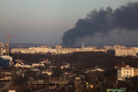 当地时间2022年3月18日，乌克兰利沃夫，机场附近建筑上空升起浓烟。当日，乌克兰利沃夫市市长安德烈·萨多维通过社交网络平台表示，俄军向利沃夫机场方向发射数枚火箭弹。有消息证实，几枚导弹击中了机场附近的飞机维修厂，建筑受损严重。乌克兰西部空军司令部稍后发消息说，一艘俄军潜艇在黑海向利沃夫方向发射了六枚巡航导弹，其中两枚被拦截。图：Roman Baluk/IC PHOTO