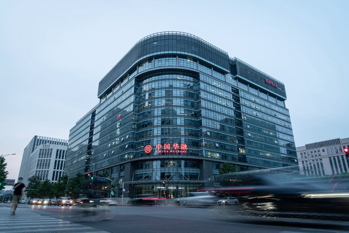 Vehicles travel past the China Huarong Asset Management headquarters on Financial Street in Beijing on May 19, 2021. Photo: Bloomberg