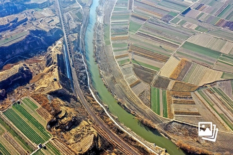 2021年1月5日，山西临汾，一列载货列车从襄汾县附近的汾河湾驶过，当地近年来立足汾河流域进行生态修复治理工作。2022年3月22至28日是第三十五届“中国水周”，今年“中国水周”的活动主题为“推进地下水超采综合治理 复苏河湖生态环境”。图/视觉中国