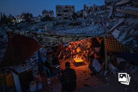 亚洲地区单幅图片奖《加沙的巴勒斯坦儿童》。当地时间2021年5月25日，巴勒斯坦加沙地区拜特拉西亚城，哈马斯和以色列之间长达11天的冲突后进入短暂的停火期，巴勒斯坦儿童们围坐在蜡烛周围。3月24日，2022世界新闻摄影比赛（荷赛）公布了地区性获奖名单。与以往相比，今年荷赛首次根据地理区域分配奖项，以期获得更平衡的全球视野。每个地区的获奖者都有机会竞逐最后的全球奖项，全球性奖项将在4月7日揭晓。图：Fatima Shbair/WPP