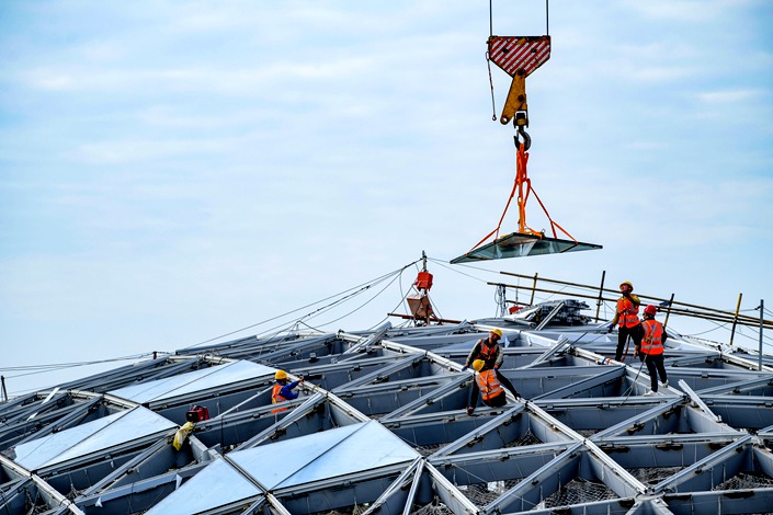 Workers install glass curtain walls at the construction site of Haikou International Duty-Free City project in Haikou, South China's Hainan province, on Feb. 24, 2022. Photo: VCG
