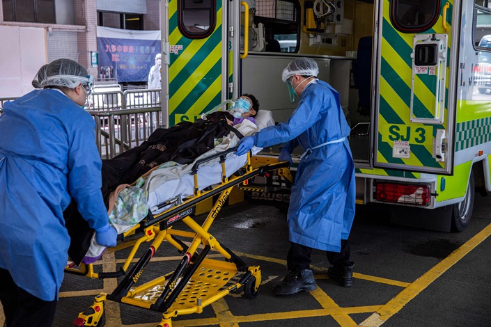 A Covid-19 patient is pulled into an ambulance in Hong Kong on March 10, 2022. Photo: VCG