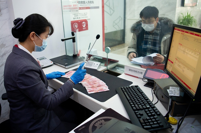 A teller takes a deposit on March 2 at a bank in Taiyuan, North China’s Shanxi Province. Photo: VCG