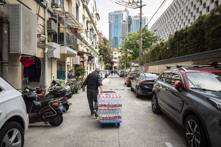 A man delivers bottled water to a neighborhood during a Covid-19 lockdown in Shanghai on Monday. Photo: Bloomberg