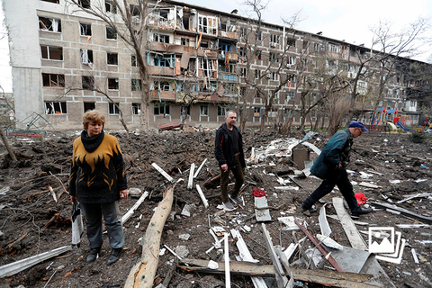 当地时间2022年4月18日，乌克兰马里乌波尔，当地居民走站在一幢受损严重的居民楼前。乌克兰战争目前已进入第八周。联合国难民事务副高级专员凯莉·克莱门茨说，目前已有500万人已经逃离乌克兰，另有700万人在乌克兰国内流离失所。联合国难民事务副高级专员凯莉·克莱门茨4月19日敦促安理会搁置分歧，找到结束这场“可怕而毫无意义的战争”的方法。图：Alexander Ermochenko/IC PHOTO