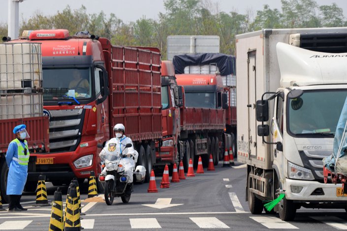Officials check drivers on the arriving trucks in Yancheng, Jiangsu province, on April 12. Photo: Bloomberg