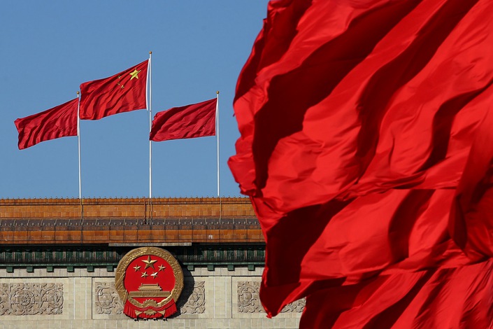 Red flags flutter in the wind near the Chinese national emblem outside the Great Hall of the People in Beijing in March 2014. Photo: Bloomberg