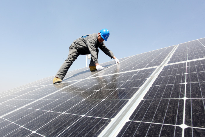 A worker inspects solar panels on April 9 at a power plant in Zhangjiakou, North China’s Hebei province. Photo: VCG