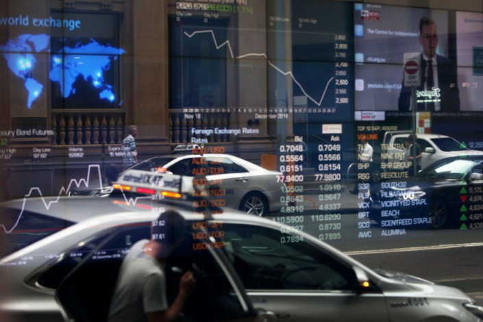 Vehicles are reflected in a window as electronic boards display stock information at the Australian Securities Exchange, operated by ASX Ltd., in Sydney, Australia, on Friday, Jan. 11, 2019. Photo: Bloomberg