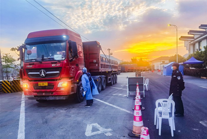 A worker checks logistics vehicles and personnel at an expressway in Hangzhou, East China's Zhejiang province, on April 10, 2022. Photo: VCG