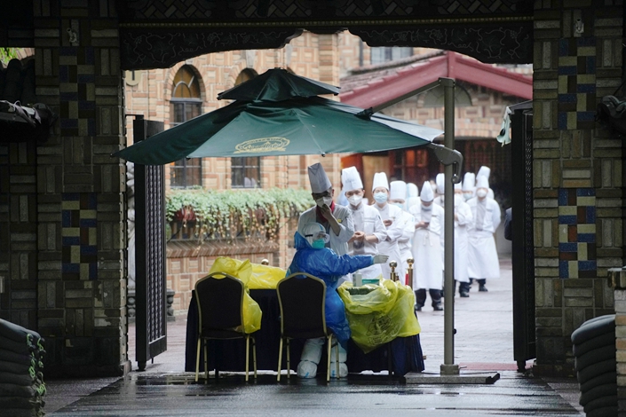 Kitchen staff line up to take the nucleic acid test in Shanghai on Friday. Photo: The Paper