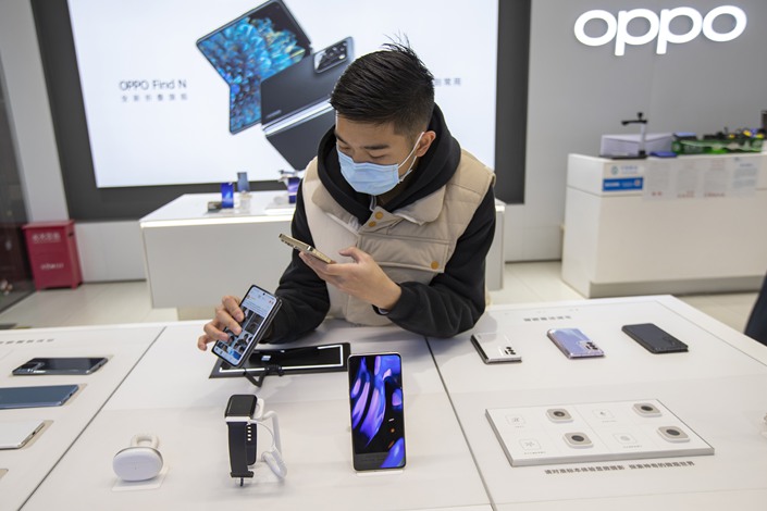 A shopper checks out a foldable phone at Oppo's flagship store in Shanghai on Dec. 24, 2021. Photo: VCG
