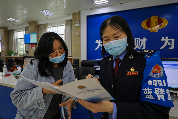A tax officer explains the tax reduction policy to taxpayers in Qujing, Yunnan Province, May 18, 2022.