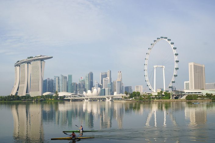 Paddlers row past the central business district at Marina Bay in Singapore on Oct. 3. Photo: Bloomberg