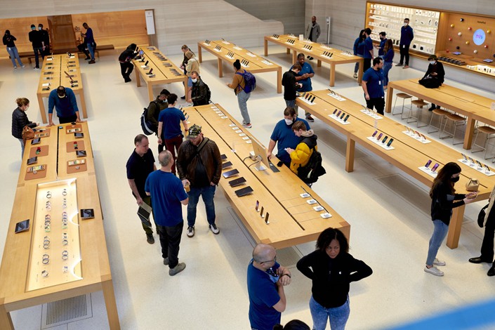 Employees assist customers during a sales launch at the Apple Inc. flagship store in New York, U.S., on Friday, March 18, 2022 Photo: Bloomberg