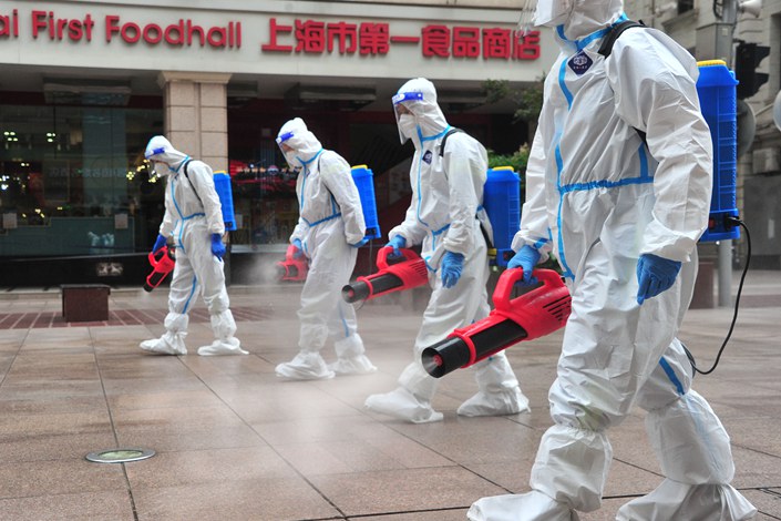 On May 28, cleaning staff spray a Shanghai street. Photo: VCG