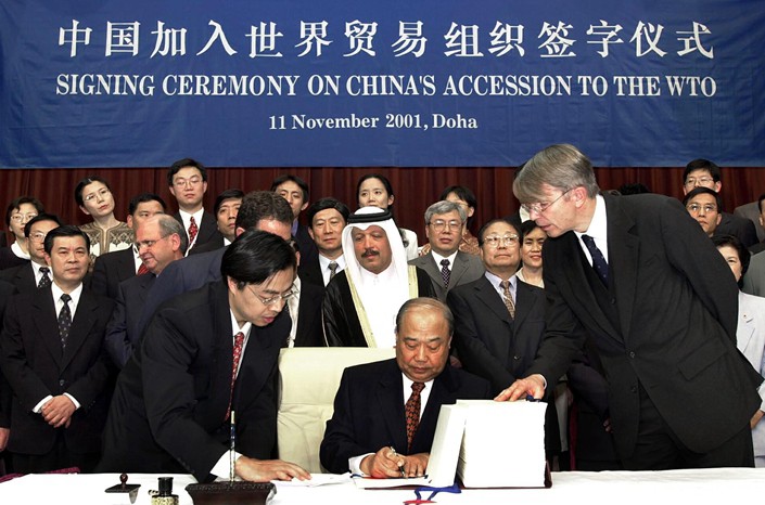 China's Foreign Trade Minister Shi Guangsheng signs the membership document during the signing ceremony for China's membership to the World Trade Organisation (WTO) in Doha on Nov. 11, 2001. Photo: VCG