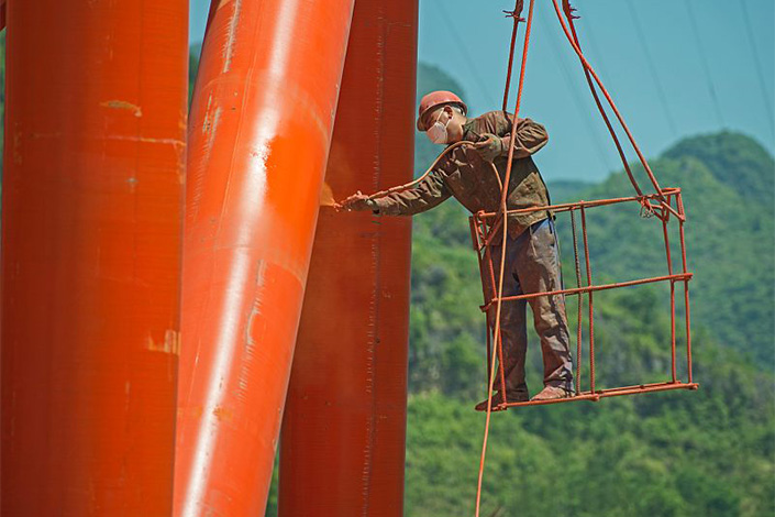 A worker paints a bridge in Southwest China's Guizhou province in 2018. Photo: VCG