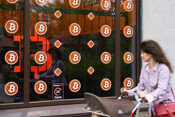 The bitcoin logo is displayed on the window of a cryptocurrency ATM kiosk in Warsaw. Photo: Bloomberg