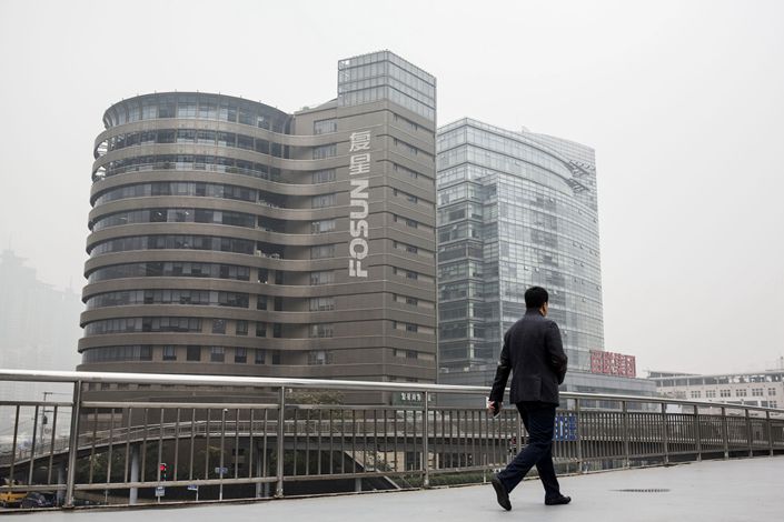 A pedestrian walks past Fosun’s headquarters in Shanghai in December 2015. Photo: Bloomberg