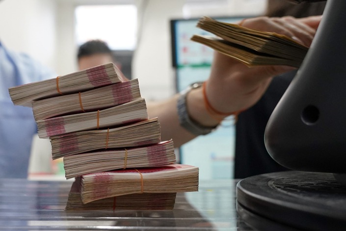 A worker counts bundles of Chinese yuan at the Ninja Money Exchange in Tokyo on June 9. Photo: Bloomberg