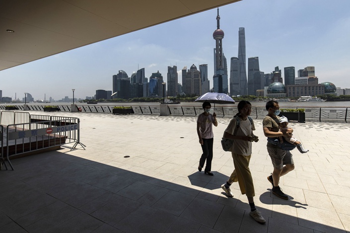 Pedestrians walk along the North Bund area in Shanghai on June 18. Photo: Bloomberg