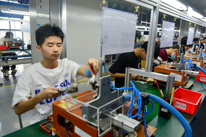 Computer science students practice making laptops at a factory in Enshi, Central China's Hubei province, June 25. Photo: VCG