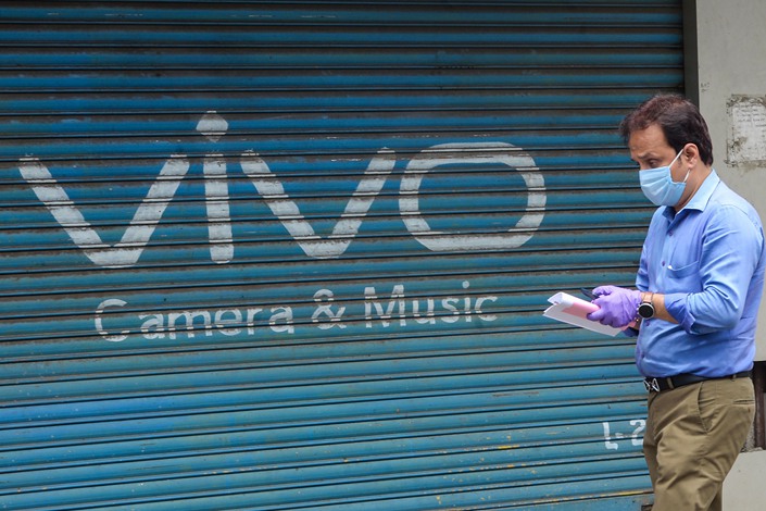 An advertisement for Chinese mobile phone maker VIVO painted on the shutters of a closed shop at a market in Mumbai, July 31, 2020. Photo: VCG