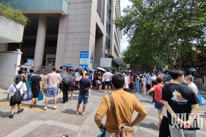 People gather outside Ruijin Hospital’s outpatient department in Shanghai on Saturday after a knife-wielding attacker injured five people, including children and staff. Photo: Shi Jing/Caixin