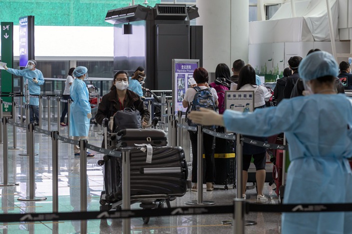 Travelers heading to quarantine in the arrival hall at Hong Kong International Airport. Photo:VCG