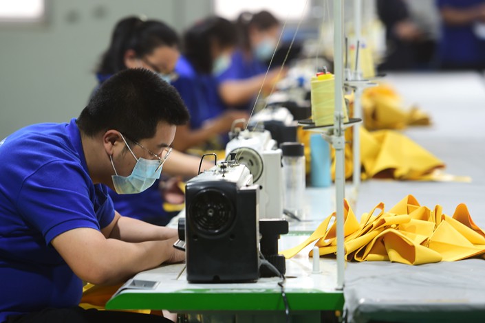 Workers produce protective products at a workshop in Cangzhou, Hebei province, April 18. Photo: VCG