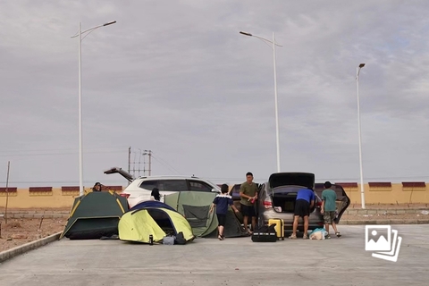8月8日， G7高速额济纳旗服务区，几名离疆的游客在服务区搭起了帐篷。据新疆维吾尔自治区人民政府新闻办公室在8月8日19:00于乌鲁木齐市召开的新闻发布会，自7月30日伊犁州报告无症状感染者以来，新疆部分地州市相继发生新冠肺炎疫情，截至8月7日24时，本次疫情已波及伊犁州、塔城、喀什、博州、阿克苏、哈密、乌鲁木齐等7个地州市12个县市区。累计报告阳性感染者274例（不含兵团），均为无症状感染者。图：财新 陈亮