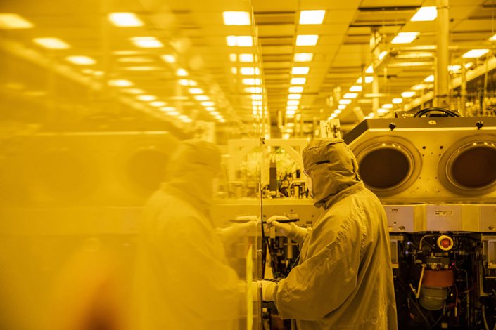 An employee wearing a cleanroom suit performs preventative maintenance inside the GlobalFoundries semiconductor manufacturing facility in Malta, New York, U.S., on March 16, 2021. Photo: Bloomberg