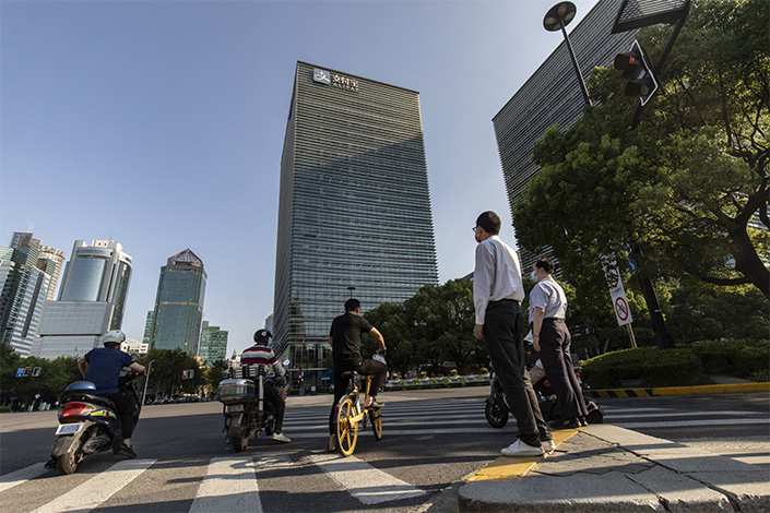 Pedestrians wait to cross an intersection near an Ant Group Co. office building in Shanghai, China, on Thursday, July 28, 2022. Billionaire Jack Ma plans to relinquish control of Ant Group, Dow Jones reported, citing people familiar with the matter said, part of the fintech giant’s effort to appease regulators following a lengthy crackdown. Photo:Bloomberg