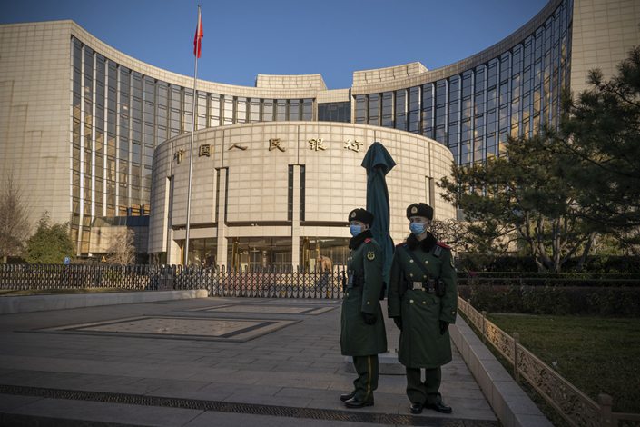 People’s Liberation Army soldiers stand in front of the People’s Bank of China in Beijing on Dec. 13. Photo: Bloomberg